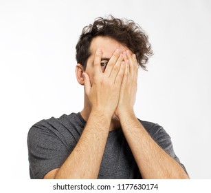 Young Man Blocking Face With Hands