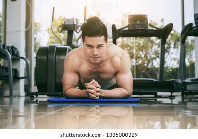 Young man bodybuilder doing push up in fitness center. Healthy lifestyle and body building concept.