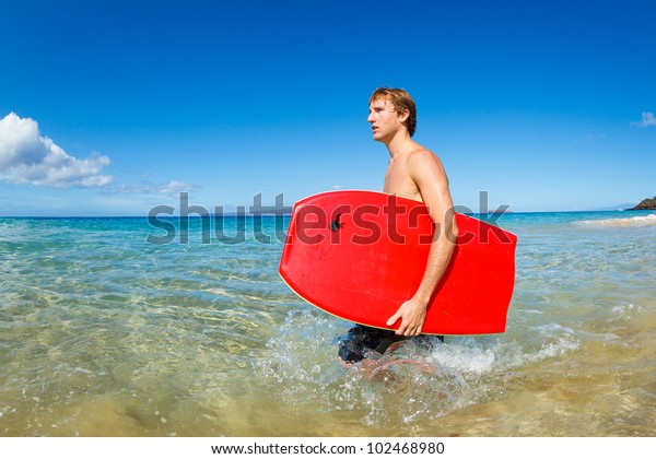 Young Man with Boogie\
Board at the Beach
