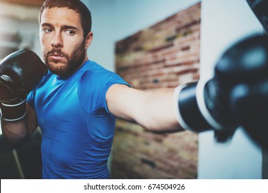 Young Man Boxing Workout In Fitness Gym On Blurred Background.Athletic Man Training Hard.Kick Boxing Concept.Horizontal