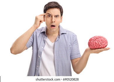 Young man with a brain model holding a finger on his temple asking do you have a brain isolated on white background