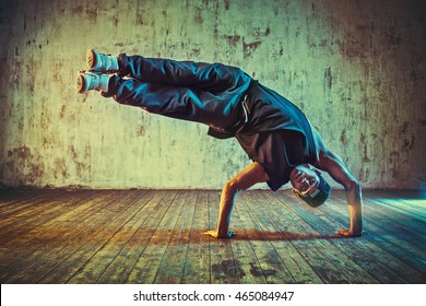Young man break dancing on wall background. Blue and yellow vibrant colors tint. - Shutterstock ID 465084947