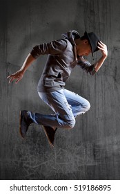 Young man break dancing on wall background