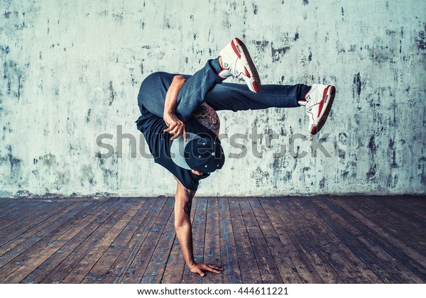 Young man break\
dancing on wall\
background