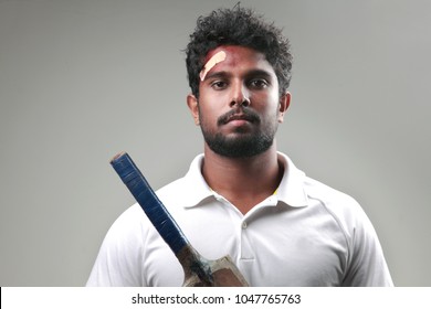 Young Man With A Bruised Forehead Holding Cricket Bat 