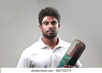 Young Man With A Bruised Forehead Holding Cricket Bat 