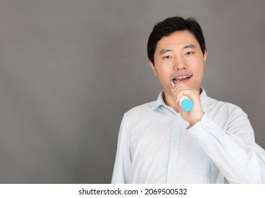 Young Man Brushing Teeth With Electric Toothbrush