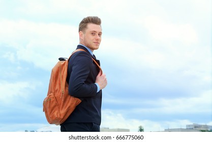 Young Man In A Business Suit And With A Backpack Behind Him After A Hard Day's Work. Life Style Of Modern Man.