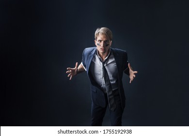 Young Man In A Business Suit Rolled Up His Sleeves And Boxing. Aggressive Business, Concept. Businessman With War Paint On His Face