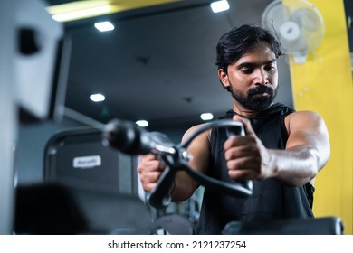 Young Man Busy Exercising For Chest While Listening Music On Wireless Headphone At Gym - Concept Of Body Building, Morning Routine And Fit Healthy Lifestyle.