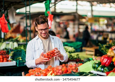 Young Man Buying Fresh Groceries At Farmer's Market.