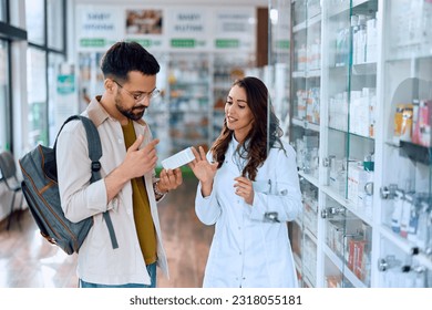 Young man buying medicine with help of female pharmacist in a pharmacy.  - Powered by Shutterstock