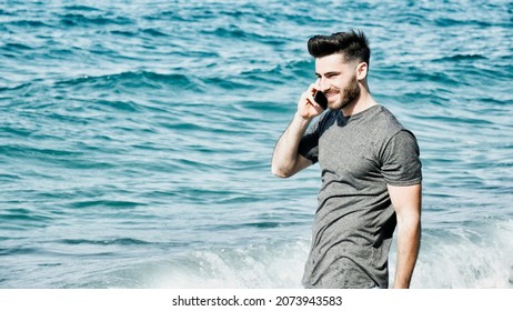 Young Man By The Sea Talking On Mobile Phone