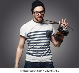 young man with camera over grey background