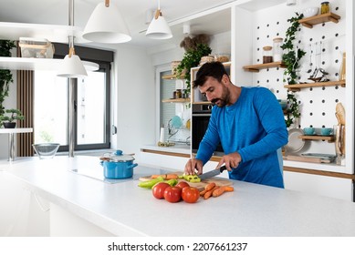 Young Man Cancer Survivor Cooking And Preparing Vegetarian Meal After Long Heavy Sickness. Vegan Male In The Kitchen Making Healthy Lunch From Fresh Vegetables Changing His Way Of Life After Illness.