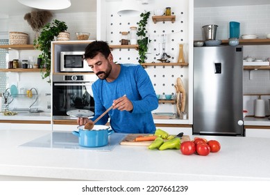 Young Man Cancer Survivor Cooking And Preparing Vegetarian Meal After Long Heavy Sickness. Vegan Male In The Kitchen Making Healthy Lunch From Fresh Vegetables Changing His Way Of Life After Illness.