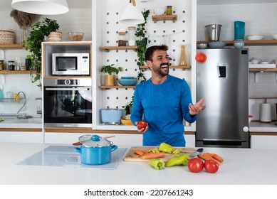 Young Man Cancer Survivor Cooking And Preparing Vegetarian Meal After Long Heavy Sickness. Vegan Male In The Kitchen Making Healthy Lunch From Fresh Vegetables Changing His Way Of Life After Illness.