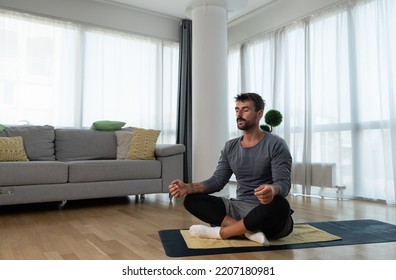 Young Man Cancer Survivor Practicing Home Workout Yoga Training, Stretching Muscles And Breathing Exercise For Healthy Life After Long Struggle With Sickness And Pain.