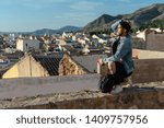 Young man with cap and jacket is looking the city. Lifestyle concept, model.
