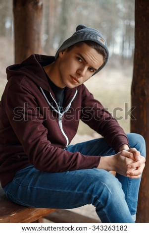 Similar – Stylish teenager sitting on a wooden bench on a city park