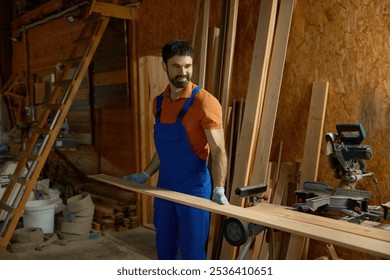 Young man carpenter in uniform putting wood plank on modern equipment - Powered by Shutterstock