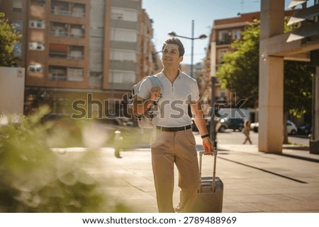 Young man carrying a backpack and pulling a suitcase, confidently walking along a sunny city street, exploring a new urban destination during his journey or business trip
