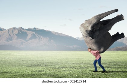 Young Man Carrying Heavy Elephant On His Back