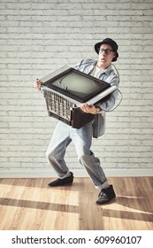 Young Man Carrying Heavy Tv Set