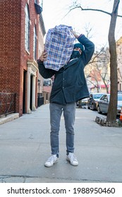 Young Man Carrying Large Bazar Bag On Shoulder For The Thrift Shop, Charity, Cleaning Space, Moving, Donation Concept. Wearing Face Mask. Outdoors