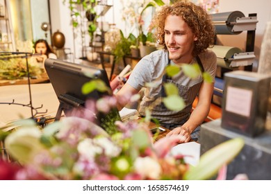 Young Man As A Cashier Or Seller At The Cash Register In The Flower Shop