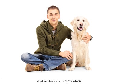 Young Man In Casual Clothes Sitting On Floor With His Labrador Retriever Dog Isolated On White Background