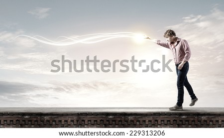 Young man in casual throwing magic light