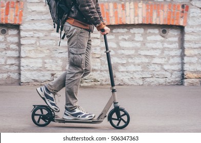 Young man in casual wear on kick scooter on city street. Toned Instagram retro vintage effect - Shutterstock ID 506347363