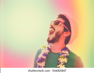 Young Man Celebrating Carnaval Holiday. Wearing Sunglasses, Hat And Flower Necklace. Color Filter And Copy Space.