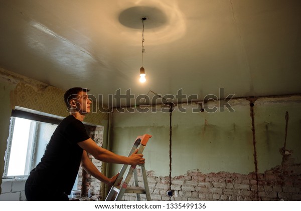 Young Man Changes Light Bulb On Stock Image Download Now