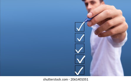 Young man checking 5 boxes with list of options on blue background - Shutterstock ID 2061401051