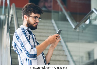 Young man checking notifications on his smartphone - Shutterstock ID 726553345