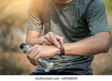 Young man checking time on his sports watch.