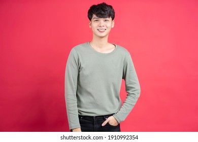 Young Man With Cheerful Expression On A Red Background