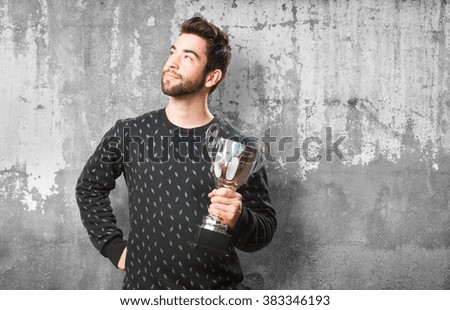 young man cheering with a trophy