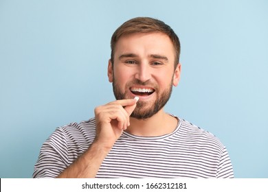 Young Man With Chewing Gum On Color Background