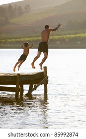 Young Man With Child Jumping To Water