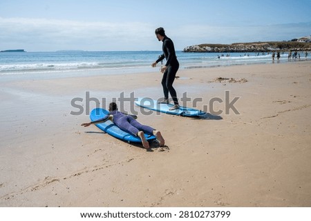 Young man and child practising surf in Portugal