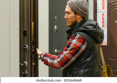 A Young Man Chooses Metal Front Door In The Hardware Store