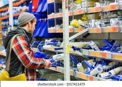 A Young Man Chooses Paint Roller In The Hardware Store