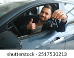 Young man is choosing a new vehicle in car dealership.