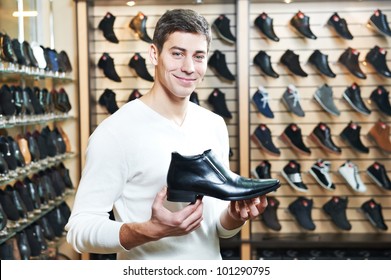 Young Man Choosing Shoes During Footwear Shopping At Shoe Shop