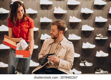 Young Man Choosing Sneakers At Sportswear Shop