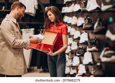 Young Man Choosing Sneakers At Sportswear Shop