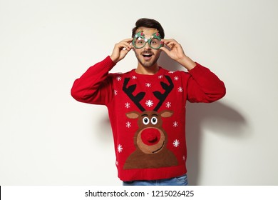 Young man in Christmas sweater with party glasses on white background - Powered by Shutterstock